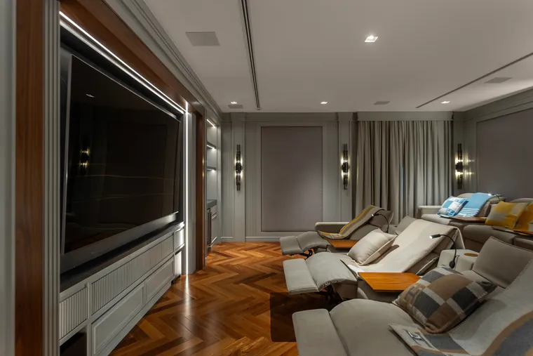 Sala de cinema com painel de TV e estantes iluminadas