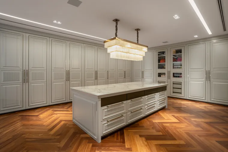 Vista geral do closet master com ilha e lustre