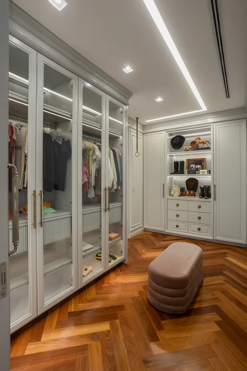 Closet com portas de vidro e nicho iluminado