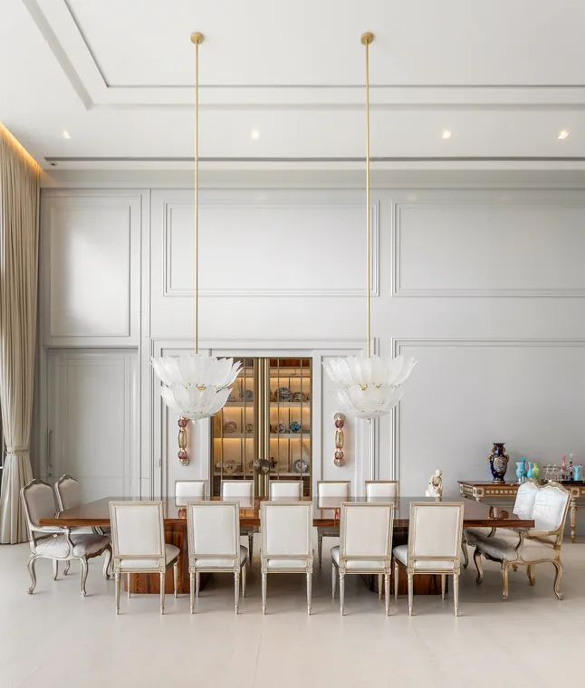 Sala de jantar com cristaleira embutida e lustres